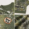 Kurzes Top aus 280 g/m² schwerem, kurzem Schnitt mit Camouflage-Tie-Dye-Muster, gefertigt aus 95 % Baumwolle und 5 % Elastan und mit einem gestickten Aufnäher. 6