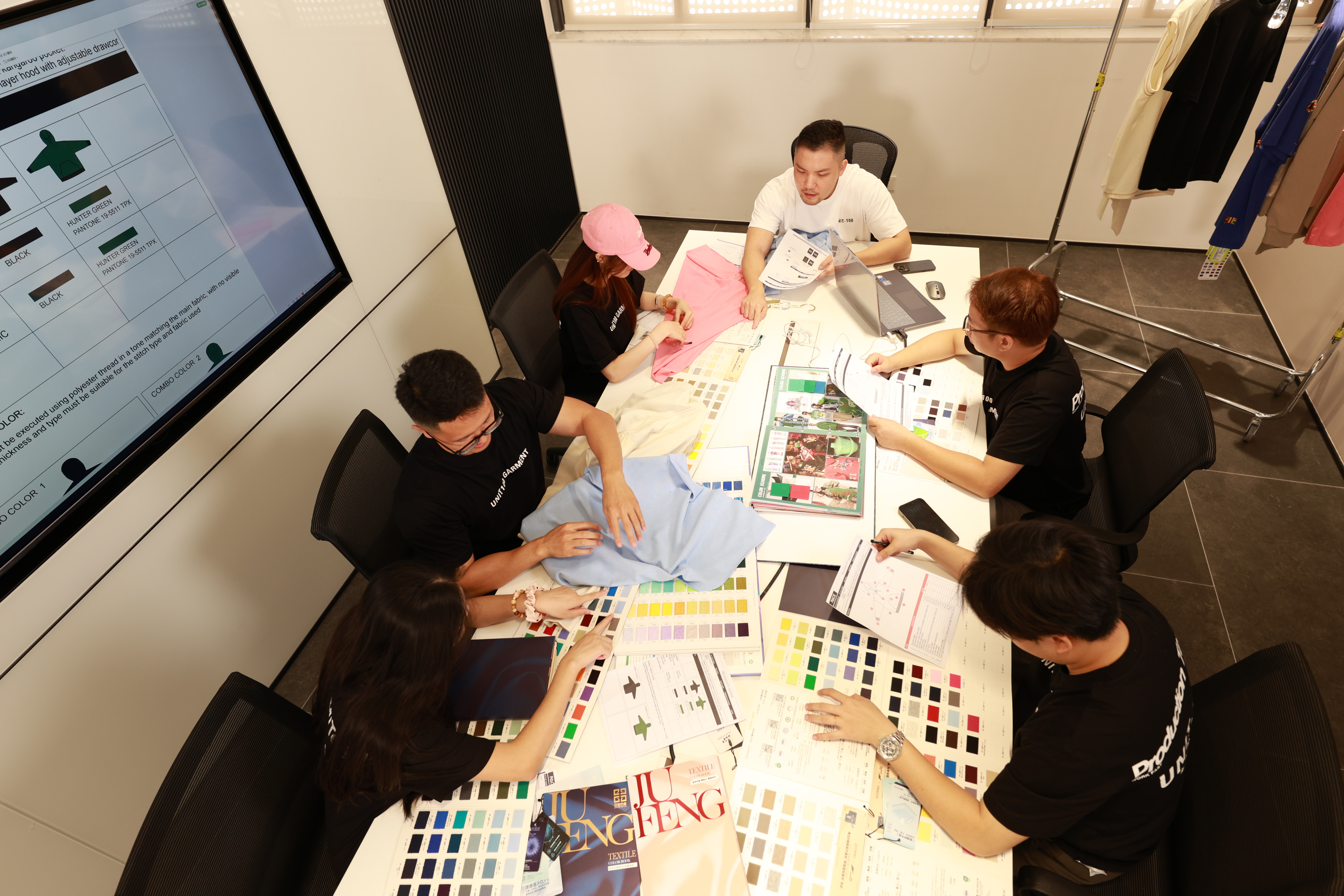 Apparel development team discussing fabric and production decisions